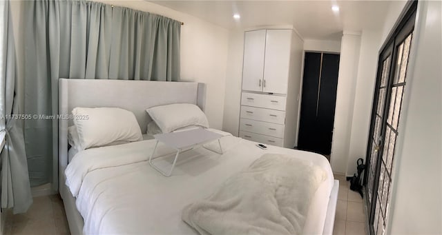 bedroom with a closet and light tile patterned flooring