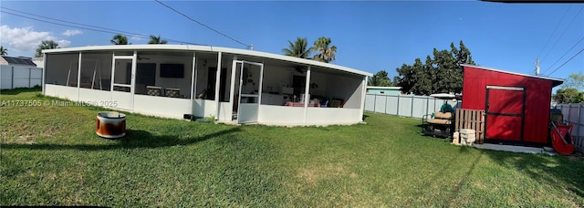 back of house with a sunroom and a lawn