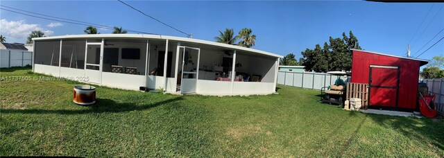 15310 Jackson Dr, Homestead, FL 33033 - rear view of property with a sunroom, a fenced backyard, ceiling fan, and a storage unit
