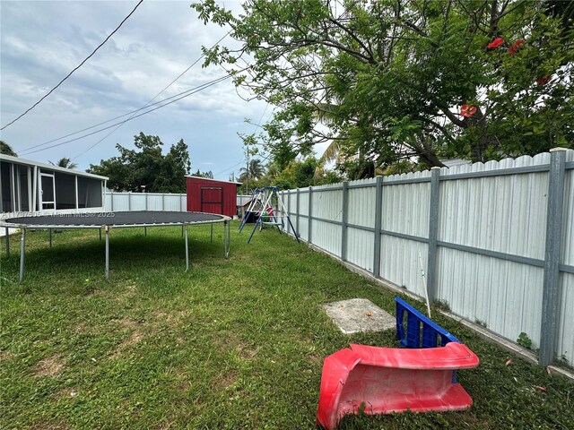15310 Jackson Dr, Homestead, FL 33033 - fenced backyard with a trampoline, a storage unit, and a playground