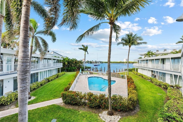 view of swimming pool featuring a yard, a patio area, and a water view