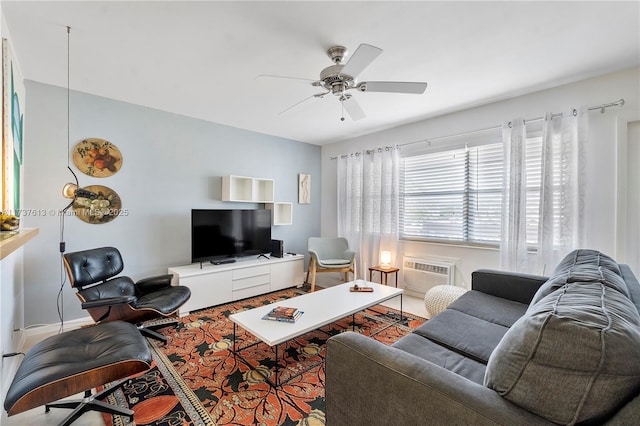 living room featuring an AC wall unit, baseboards, and ceiling fan