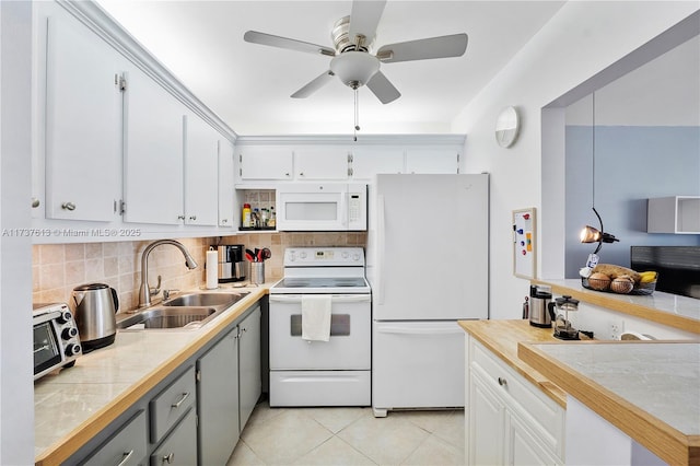 kitchen featuring white appliances, light countertops, a ceiling fan, decorative backsplash, and a sink
