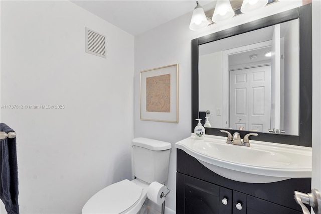 bathroom featuring vanity, visible vents, and toilet