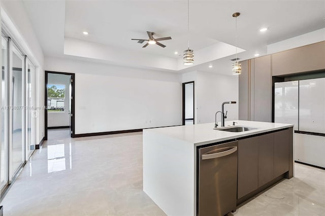 kitchen with modern cabinets, a tray ceiling, light countertops, and a sink