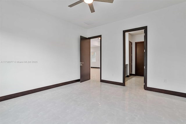 empty room with a ceiling fan and baseboards