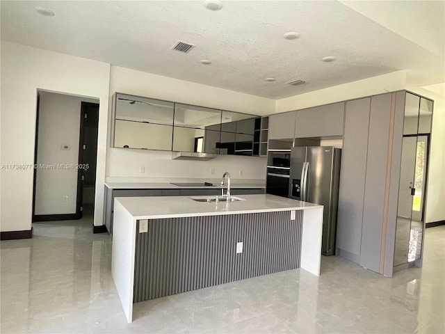 kitchen with visible vents, gray cabinets, stainless steel fridge, modern cabinets, and a sink