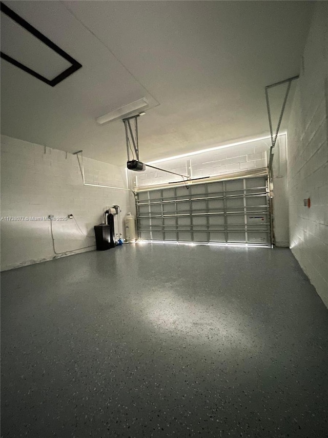 garage with concrete block wall and a garage door opener