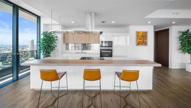 kitchen with white cabinetry, sink, dark hardwood / wood-style flooring, a wall of windows, and black appliances