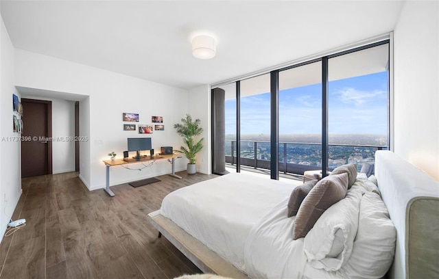 bedroom with expansive windows and hardwood / wood-style floors