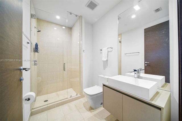 bathroom featuring vanity, toilet, tile patterned flooring, and a shower with door