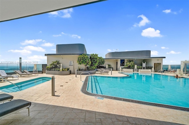 view of swimming pool with a patio and a water view