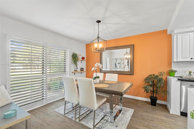 dining area with dark hardwood / wood-style floors and a chandelier