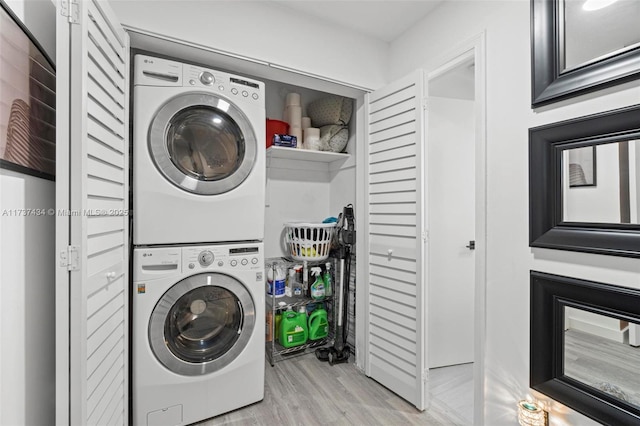 washroom with stacked washer and dryer and light wood-type flooring