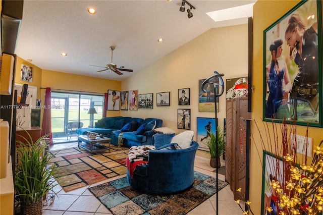 living room with light tile patterned flooring, ceiling fan, and lofted ceiling with skylight