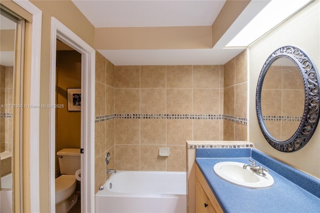 bathroom featuring a washtub, vanity, and toilet