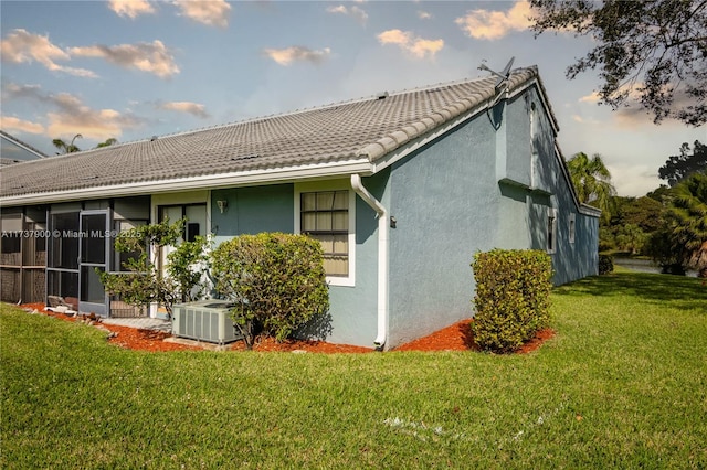 back of house featuring cooling unit and a lawn