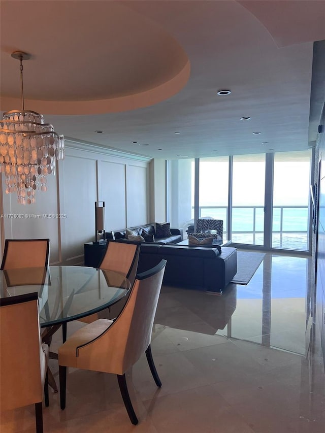 dining room with expansive windows and a water view