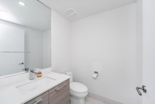 bathroom featuring tile patterned floors, vanity, and toilet