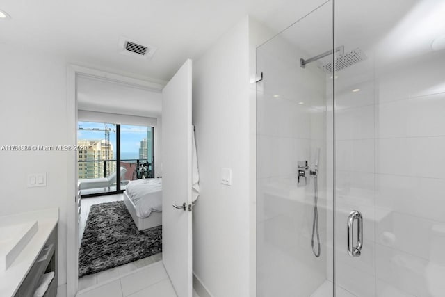 bathroom featuring tile patterned flooring, vanity, and an enclosed shower