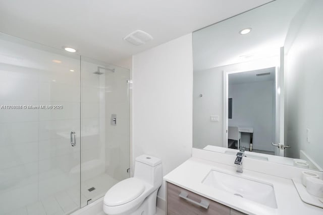 bathroom featuring a shower with door, vanity, and toilet