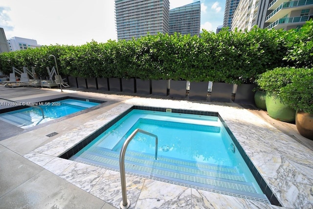 view of swimming pool featuring an in ground hot tub