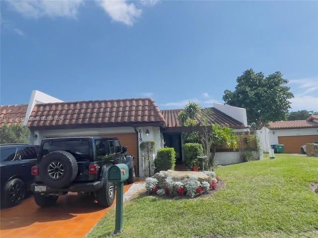 mediterranean / spanish-style home with a garage and a front lawn