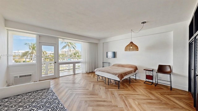 bedroom featuring access to outside, a wall mounted air conditioner, baseboards, and multiple windows