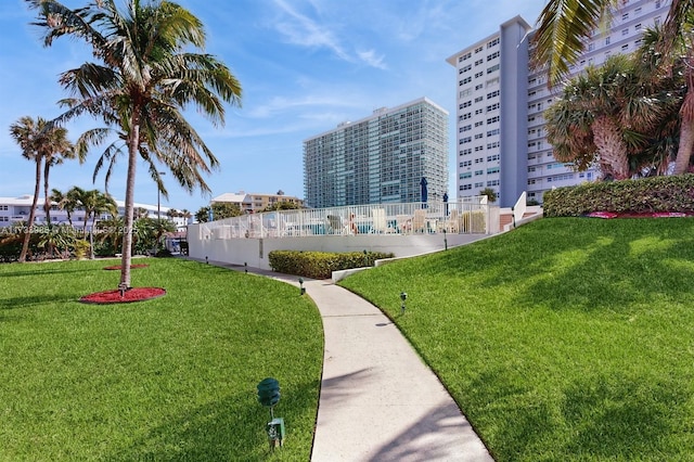 view of property's community featuring a city view, a yard, and fence