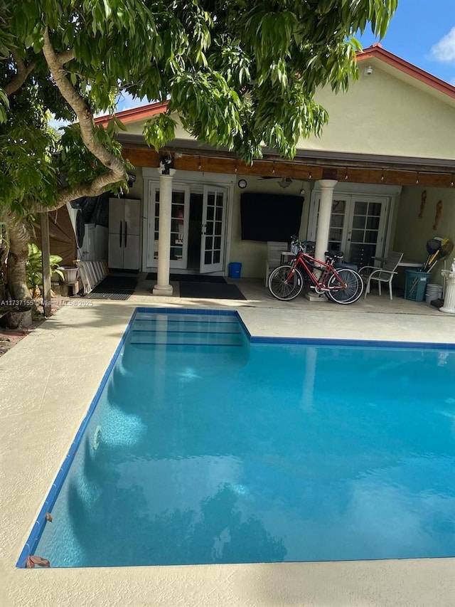 view of pool featuring a patio area and french doors