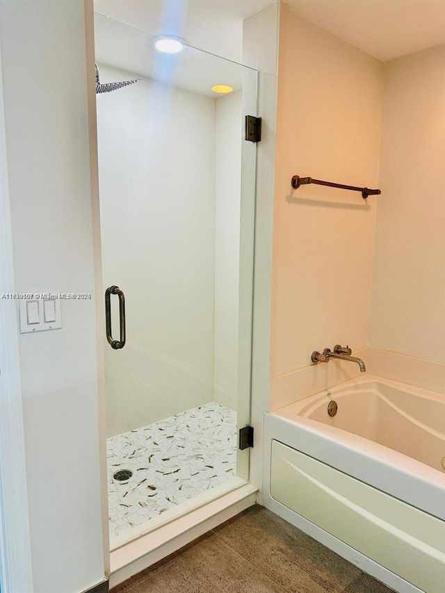 bathroom featuring shower with separate bathtub