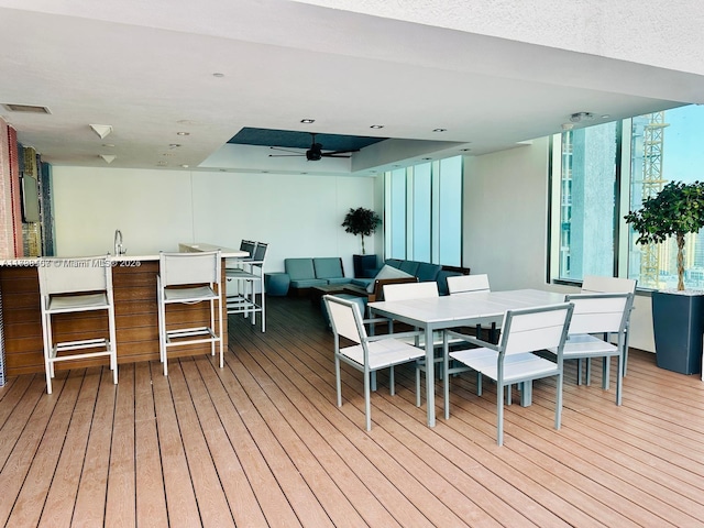 deck featuring ceiling fan, an outdoor hangout area, and a wet bar