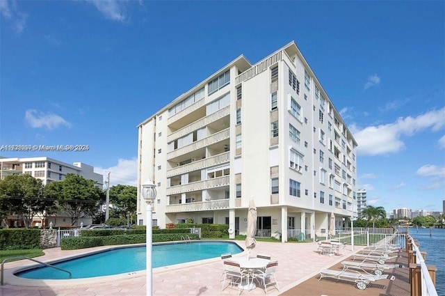 view of swimming pool featuring a patio area and a water view