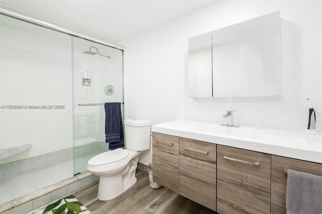 bathroom featuring vanity, hardwood / wood-style floors, toilet, and walk in shower