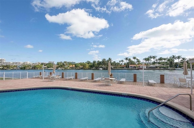 view of pool with a patio area and a water view