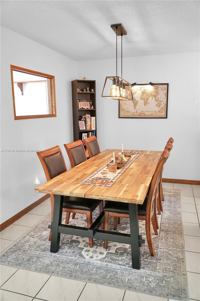 tiled dining area featuring a textured ceiling