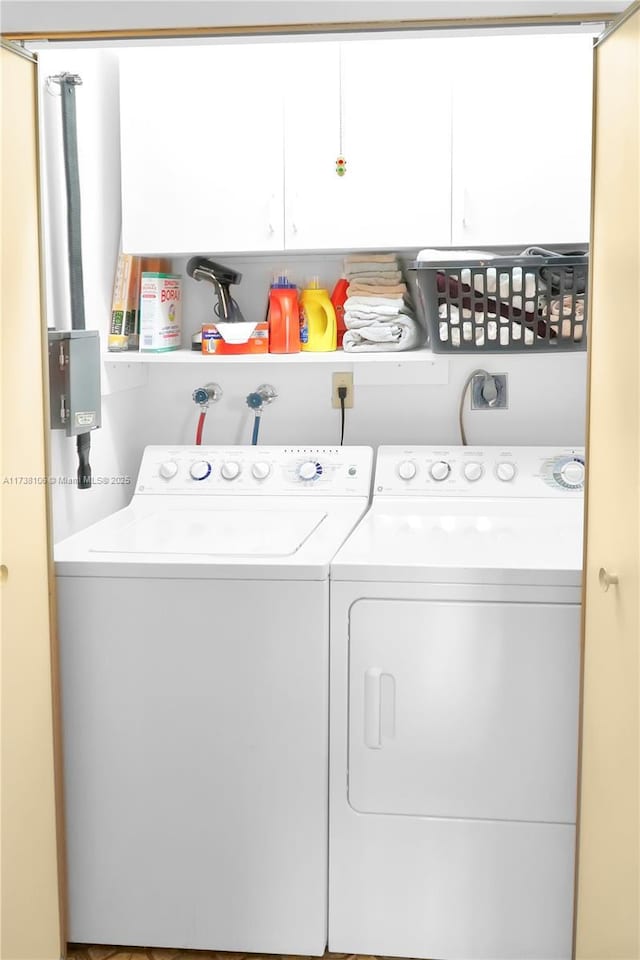 clothes washing area with cabinets and washing machine and clothes dryer