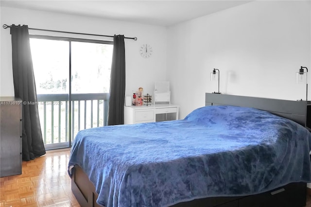 bedroom featuring multiple windows, access to exterior, and light parquet floors