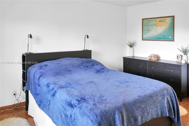 bedroom featuring dark parquet flooring