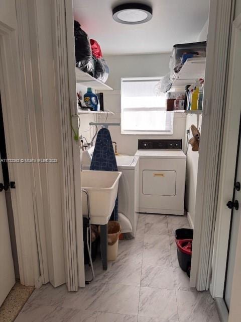 clothes washing area with washer and dryer, marble finish floor, and laundry area