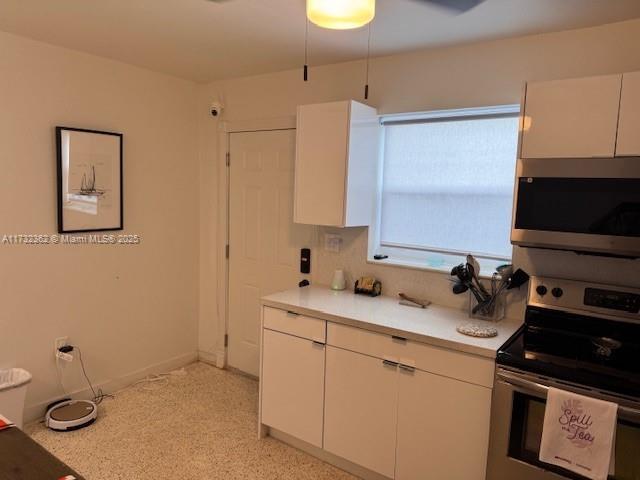 kitchen with white cabinets, appliances with stainless steel finishes, and light countertops