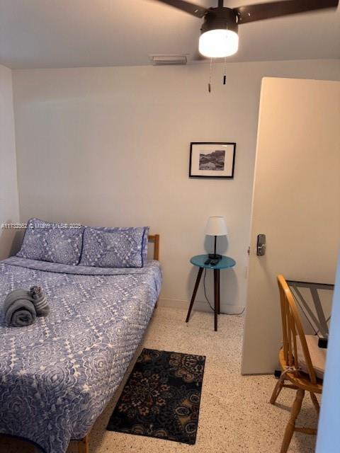 bedroom with ceiling fan, visible vents, and speckled floor