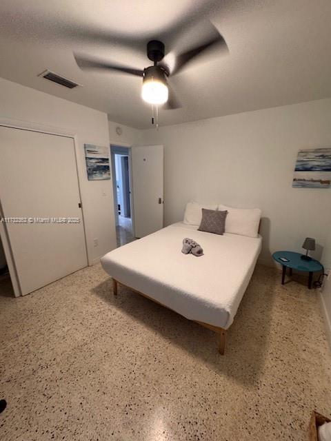 bedroom featuring a ceiling fan, visible vents, and speckled floor