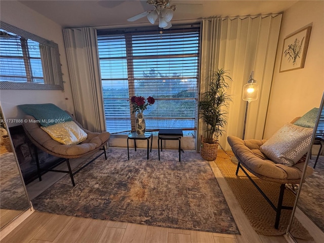 sitting room with hardwood / wood-style flooring and ceiling fan