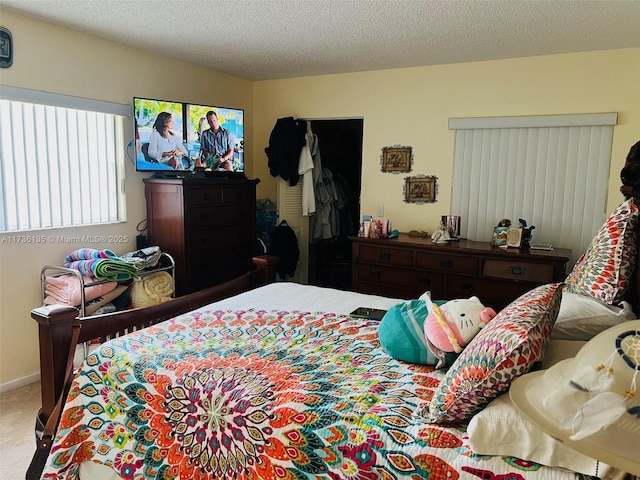 bedroom with a textured ceiling and carpet flooring