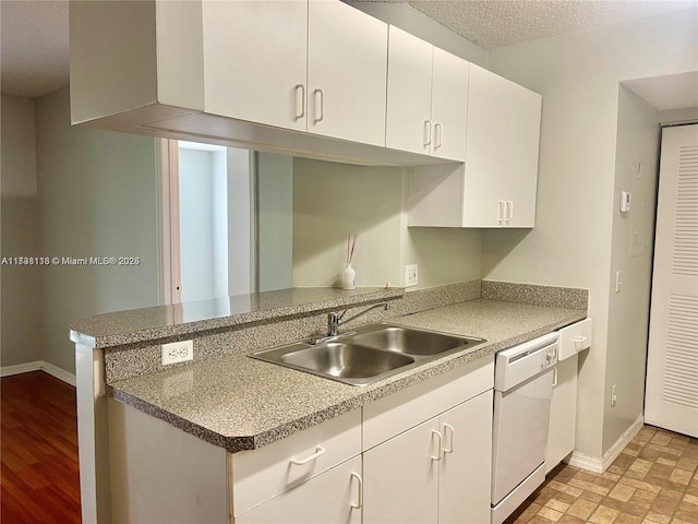 kitchen featuring sink, white cabinets, white dishwasher, kitchen peninsula, and a textured ceiling