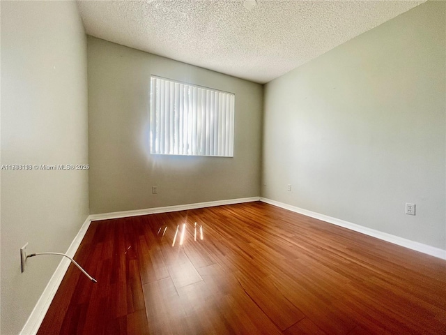 unfurnished room featuring hardwood / wood-style floors and a textured ceiling