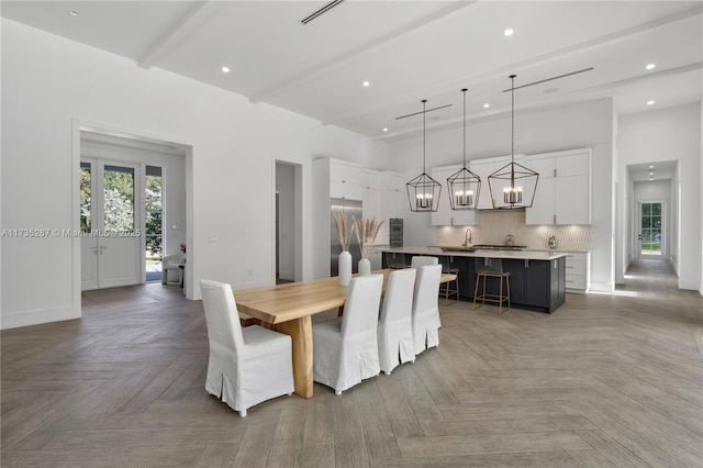 dining room with a high ceiling, parquet flooring, and beam ceiling