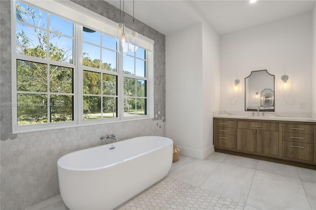 bathroom featuring plenty of natural light, a bath, tile patterned flooring, and vanity