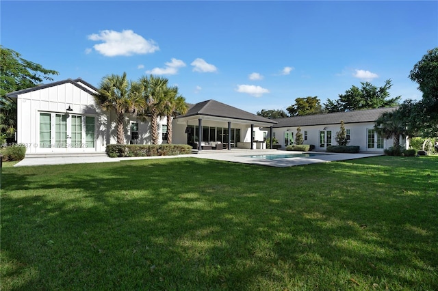 rear view of house with a yard, a patio area, and french doors